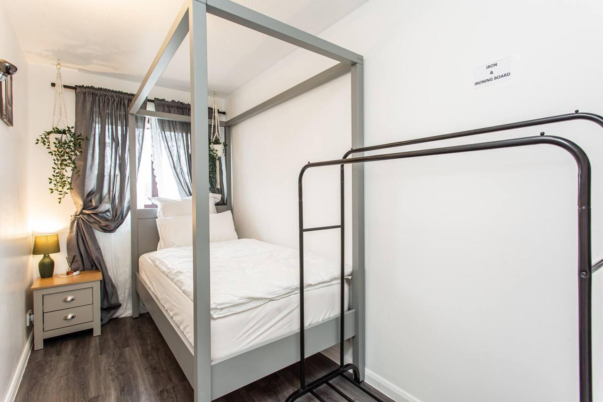 A bedroom with a bed, a bedside table with a lamp, and a metal ladder.