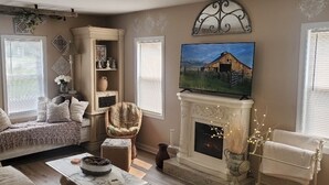 Una sala de estar acogedora con chimenea, televisor y zona de estar confortable.