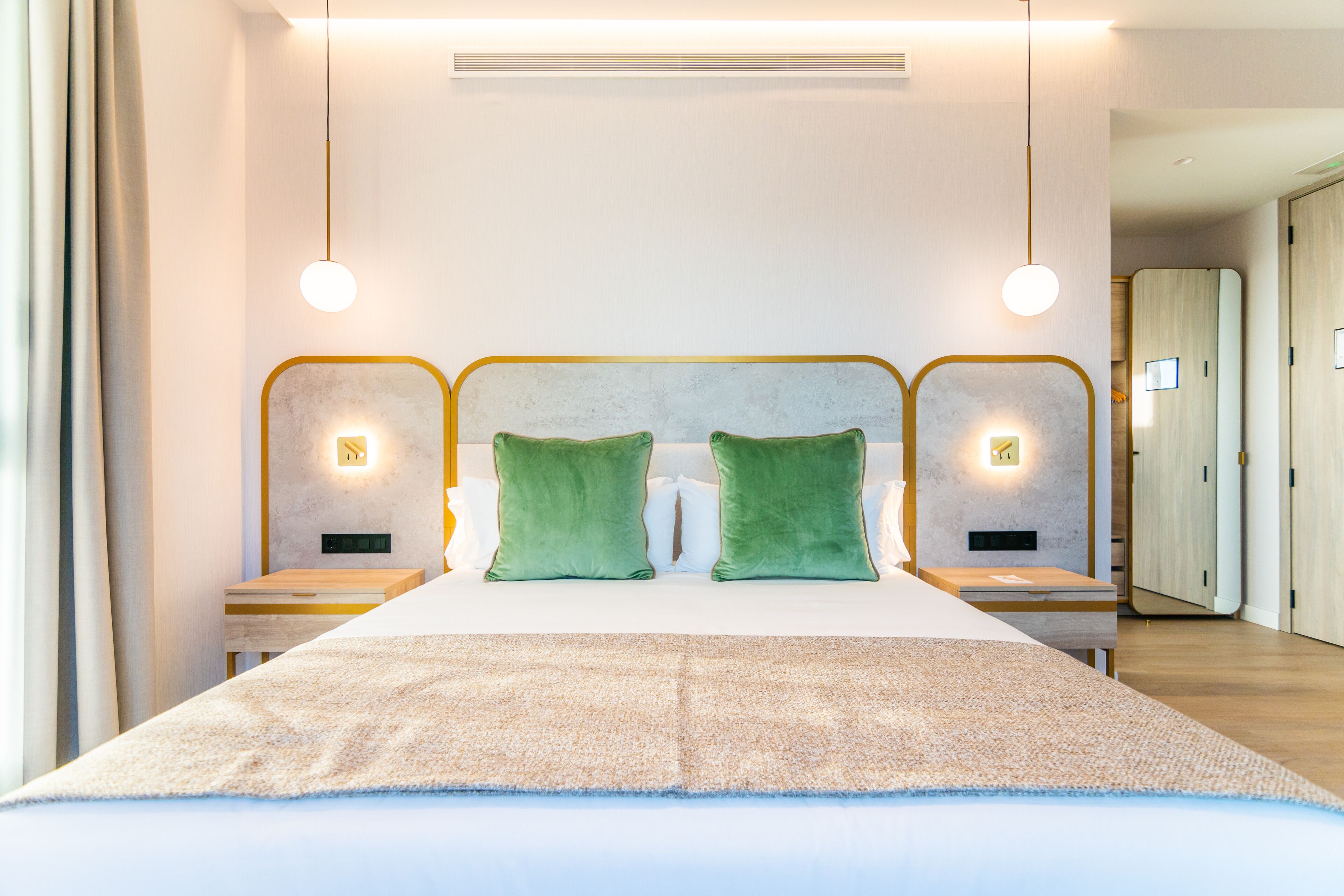 Una camera d'albergo moderna con un letto grande, due comodini e un armadio.