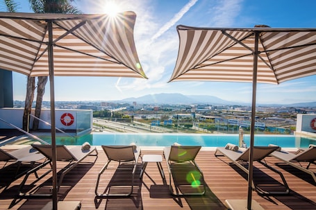 Una piscina al aire libre de temporada, sombrillas
