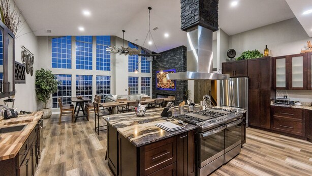 A modern kitchen with a large island, built-in appliances, and a dining area with natural light. - New Luxury Prescott Lynx B B 4k ft2 Sleeps 22 (Prescott)