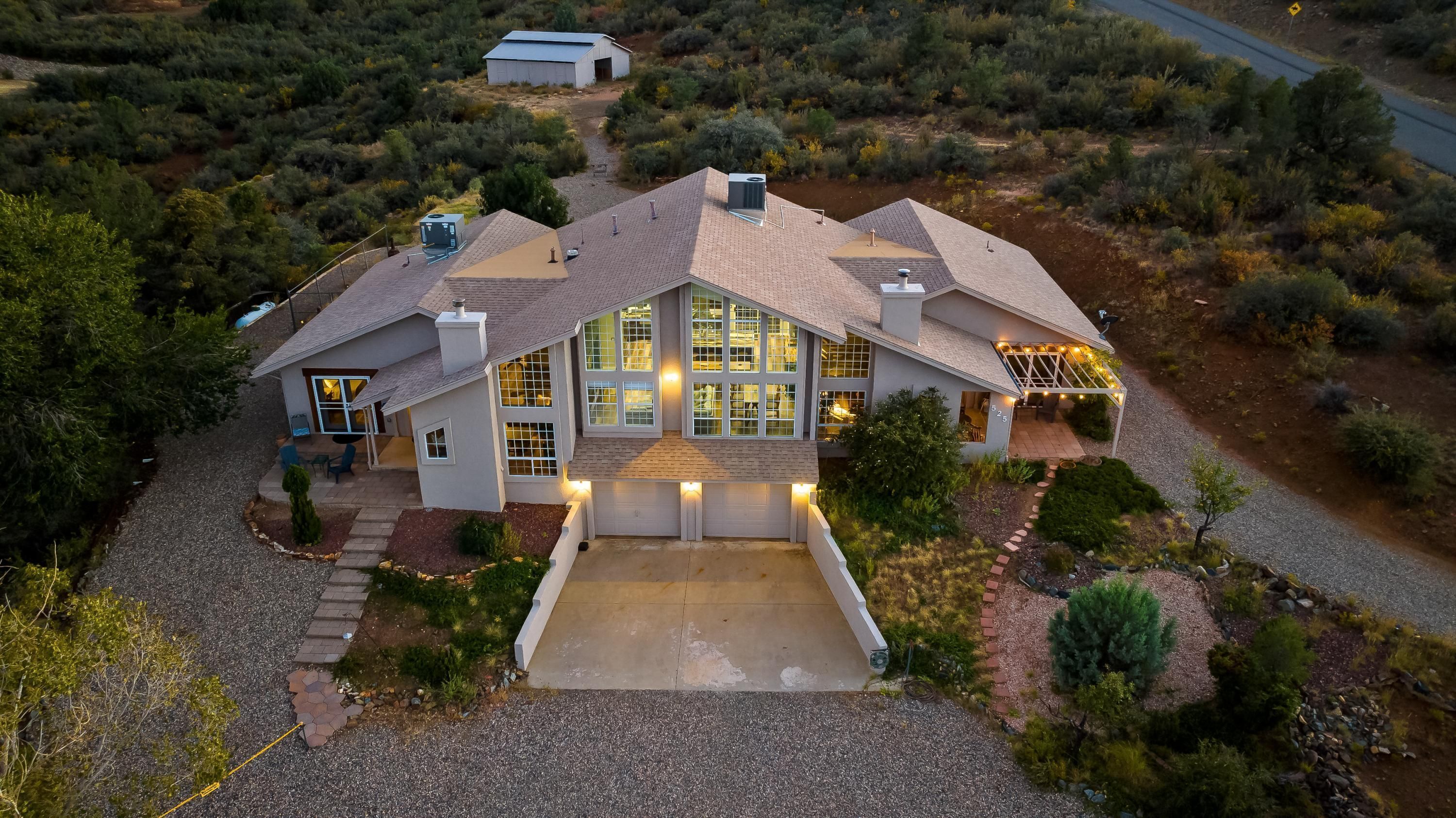 A large, modern house with a spacious garage, a covered patio, and a well-maintained garden.