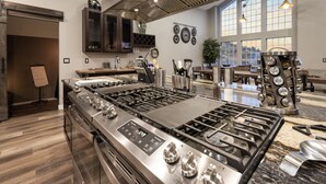 A modern kitchen with stainless steel appliances, a large island, and a dining area with a view. - New Luxury Prescott Lynx B B 4k ft2 Sleeps 22 (Prescott)