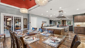 A spacious dining area with a large wooden table set for a meal, surrounded by chairs. - Spacious Canyon Peak Pine View Home Game Room Hot Tub (Flagstaff)