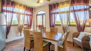 A dining area with a wooden table, wicker chairs, and a ceiling fan. - Your vacation surrounded by greenery at Villa Irde (6 rooms 6 bathrooms) (Alghero)