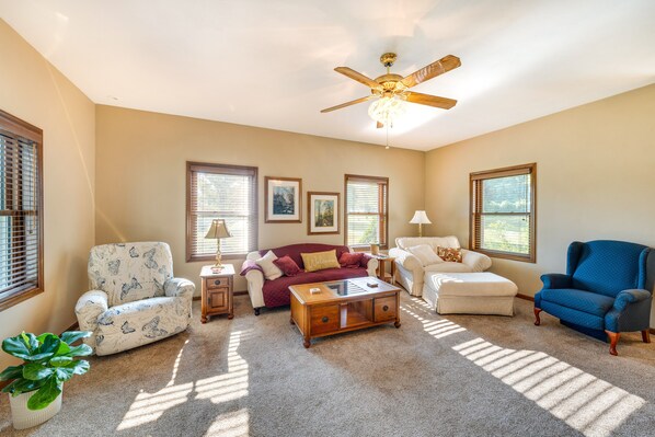 A living room with a ceiling fan, a coffee table, a sofa, and a blue armchair.