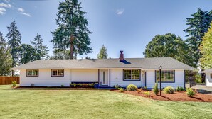 A single-story house with a front porch, a chimney, and a well-maintained lawn. - Chehalis Getaway w/ Golf Course View + Fire Pit! (Chehalis)