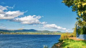 A coastal landscape with a clear view of the sea, a path leading to a cliff, and distant hills. - Arenig - Bala Lake (Bala)