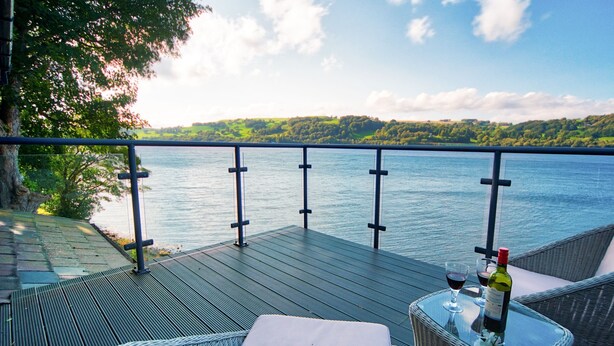 A terrace with wicker furniture, a glass table, and a bottle of wine. - Arenig - Bala Lake (Bala)