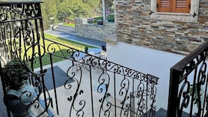 A balcony with a stone wall and wooden shutters, overlooking a green landscape. - Refugio, Castelo de Paiva (Pedorido)