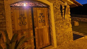 A stone building with a wooden door featuring decorative metalwork. - Refugio, Castelo de Paiva (Pedorido)