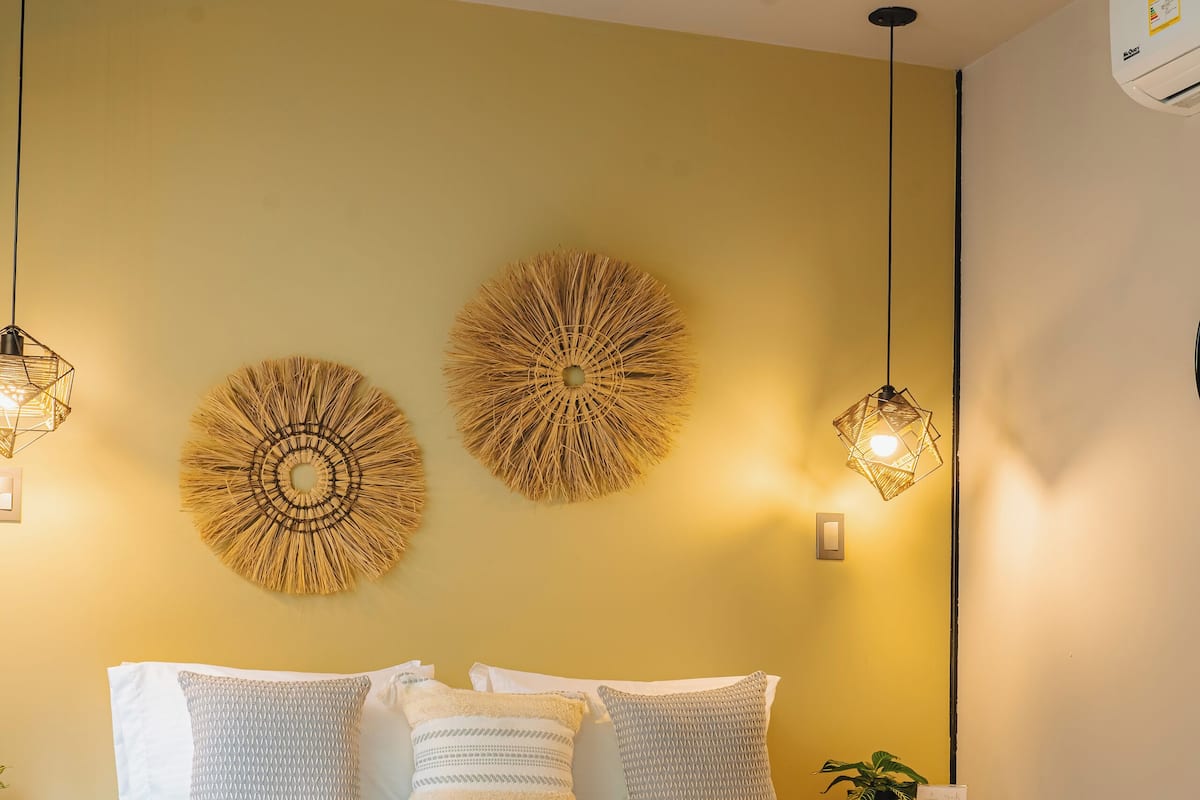 A bedroom with a bed, two wall-mounted lamps, and a wall decoration.