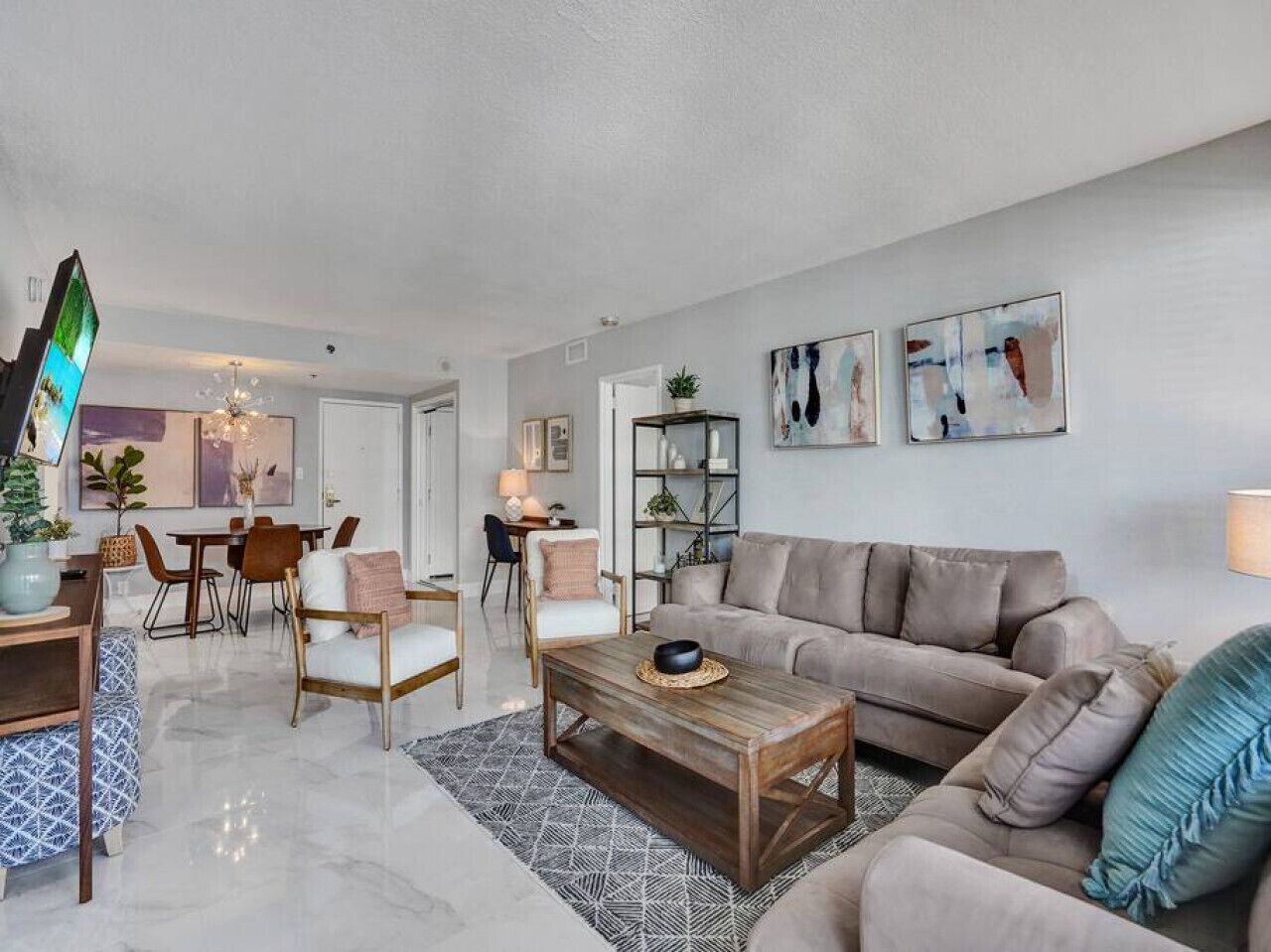 A modern living room with a beige sofa, a wooden coffee table, and a dining area with a table and chairs.