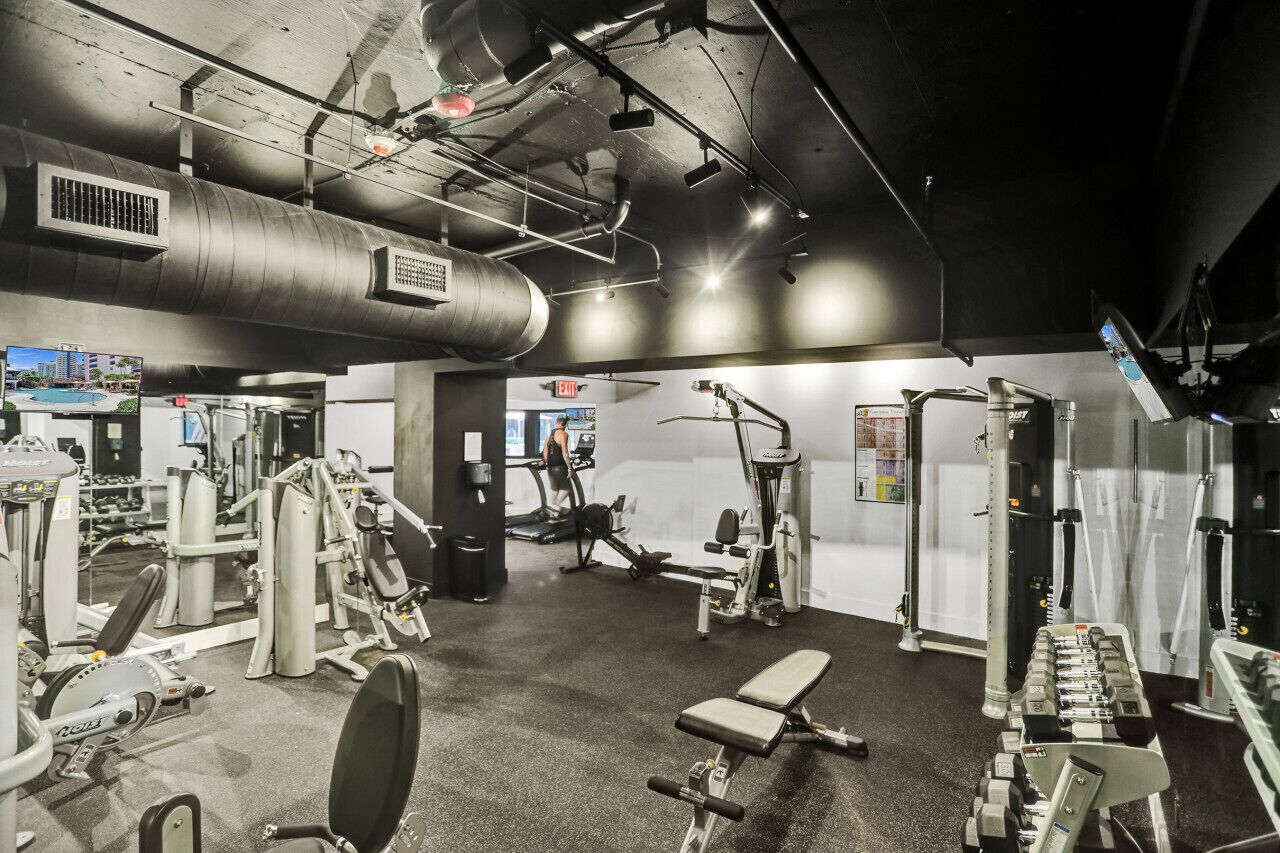 A gym with various exercise equipment, a treadmill, and a bench.