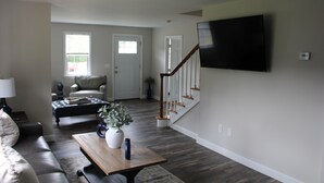 Ein Wohnzimmer mit Sofa, Couchtisch und Fernseher.