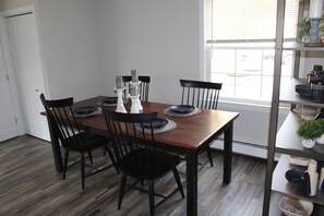 A dining area with a wooden table, black chairs, and white candle holders. - Central, Charming & Modern Home (Lakeville)