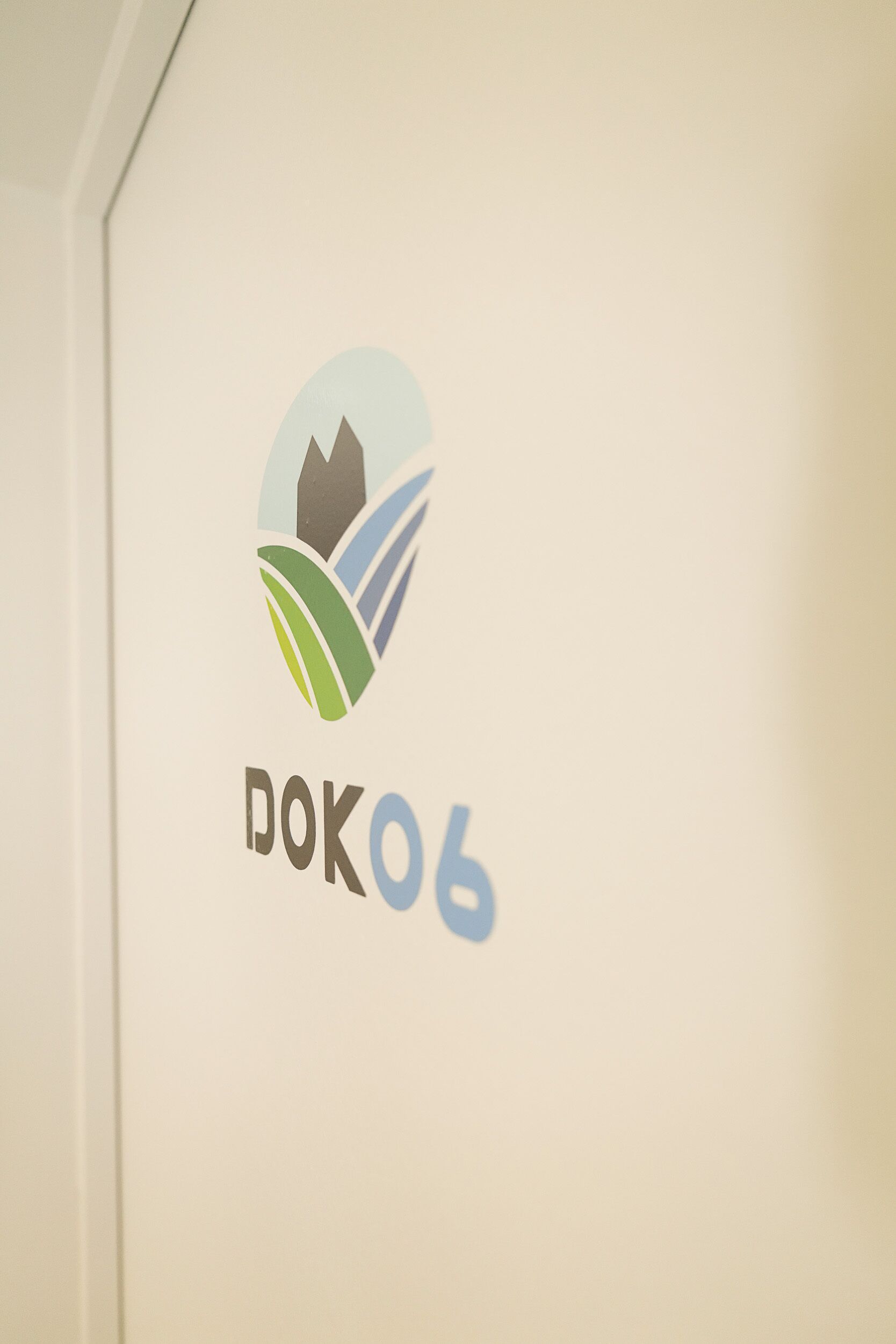 Ein Logo mit einer Berg- und Blattform, sowie dem Text "DOK06".