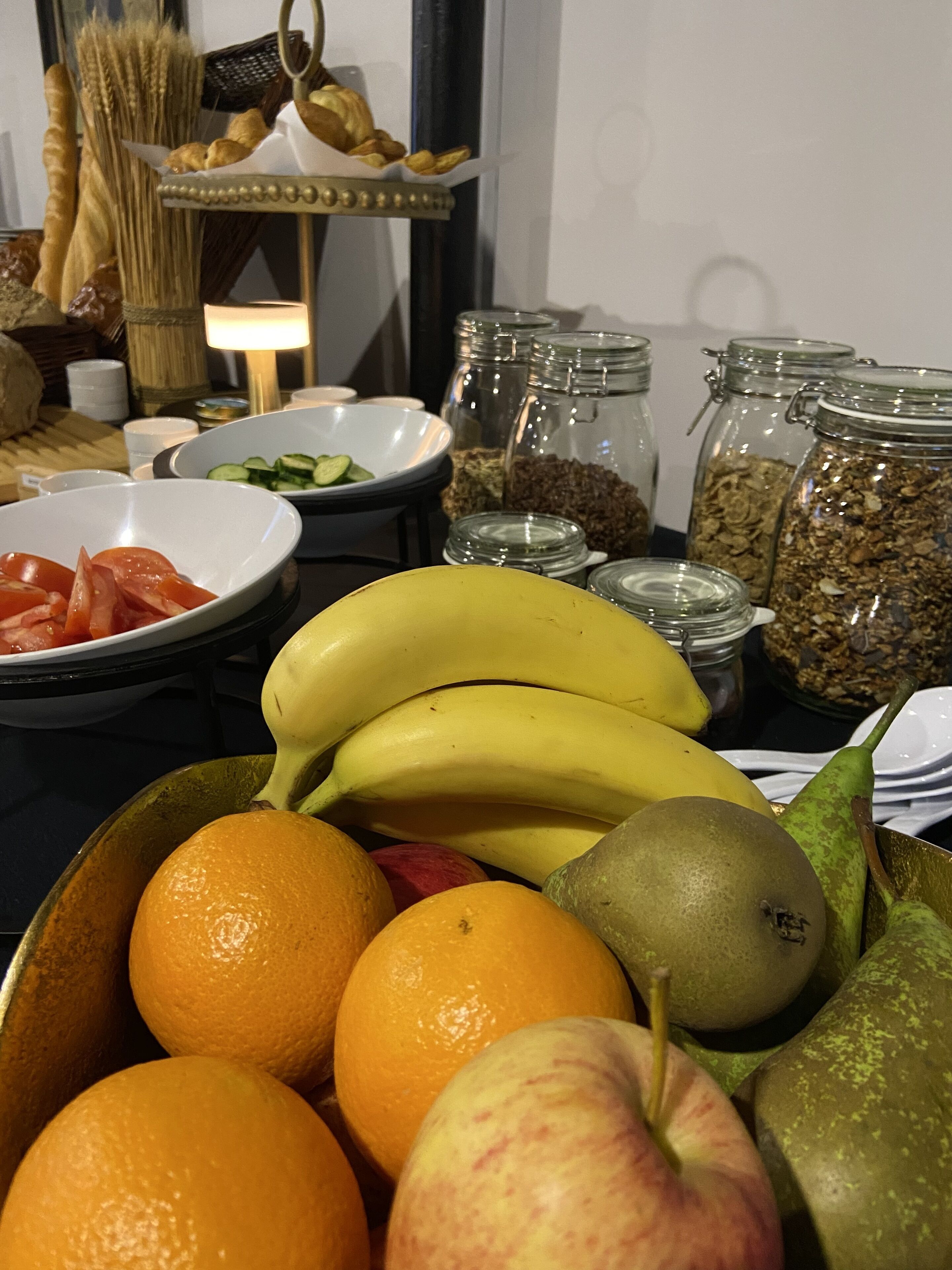 A table with a variety of fruits and snacks, including bananas, oranges, and apples.