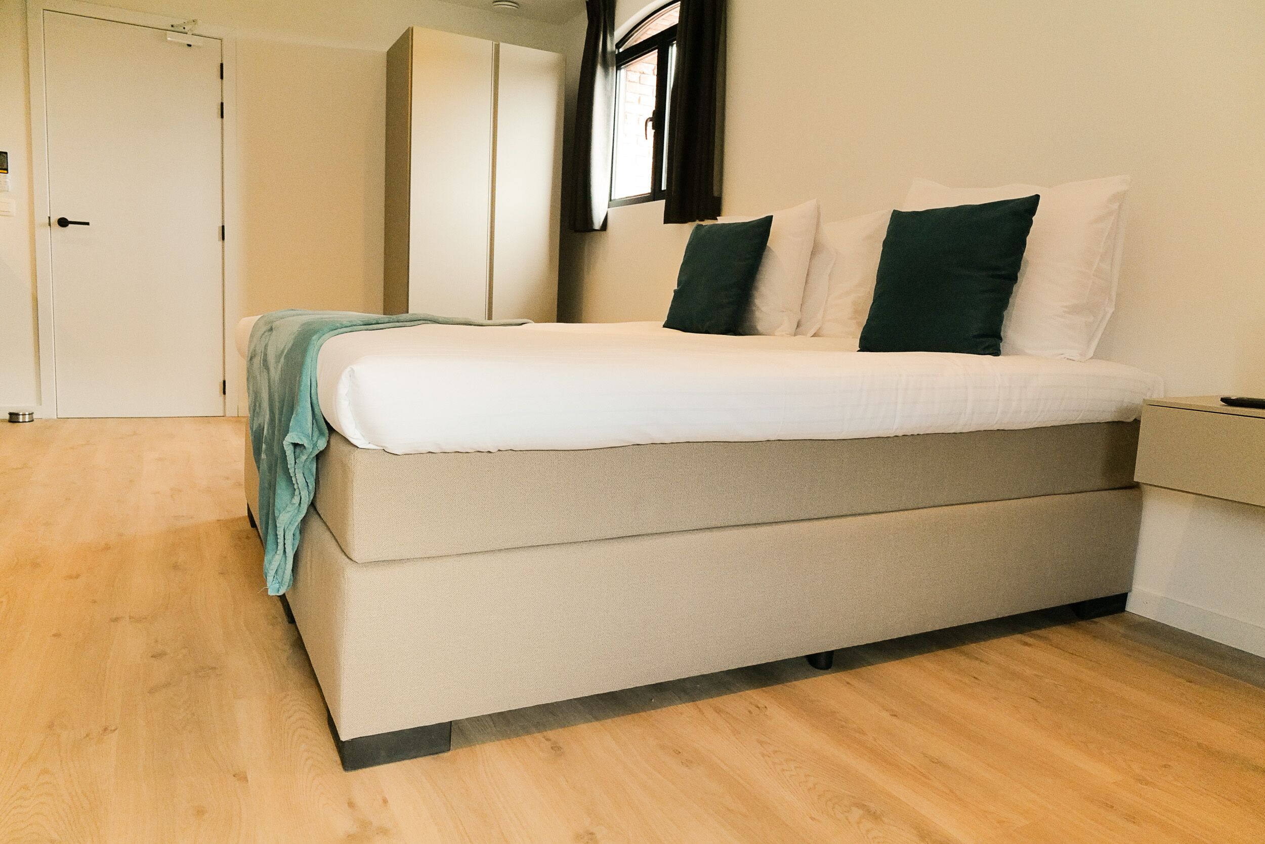 Un dormitorio moderno con una cama, un armario y una ventana.