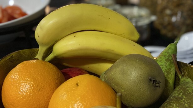 Una mesa con una variedad de frutas, como plátanos, naranjas y manzanas.