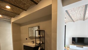 A modern bathroom with a built-in sink, a mirror, and a black shelving unit. - HVN10 B&B (Stabroek)