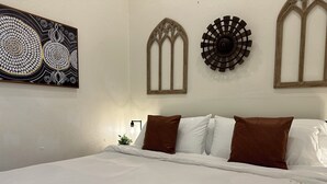 Un dormitorio con una cama grande, dos apliques decorativos y un reloj de pared.
