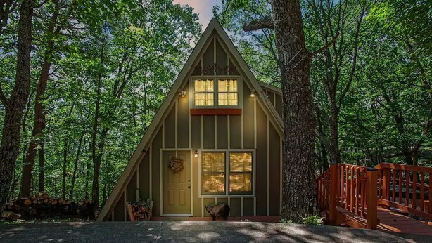 A cabin with a triangular roof, a front porch, and a wooden deck. - Cameo Tree Top Chalet - HOT TUB and Pet Friendly (Jasper)