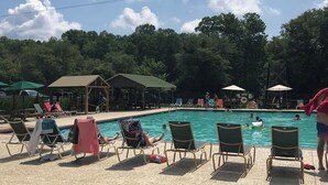 A pool area with lounge chairs, a pool, and a covered pavilion. - Cameo Tree Top Chalet - HOT TUB and Pet Friendly (Jasper)