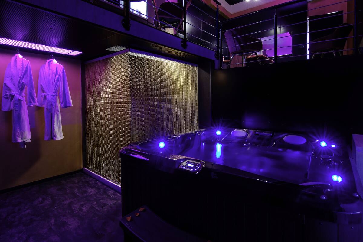 A spa room with a hot tub, towels, and a soundproof wall.