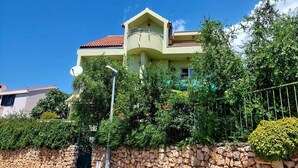 A two-story house with a stone wall, a balcony, and dense greenery. - Apartment in Žaborić with Seaview, Balcony, Air condition, WIFI (5177-1) (Šibenik)