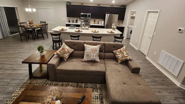 A modern apartment with a living room, dining area, and kitchen.