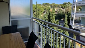 A balcony with a view of a residential area, a table, and chairs. - FABRA Apartment (Salou)
