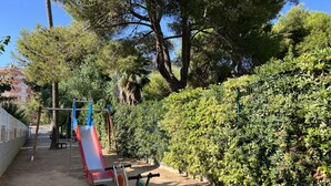 A playground with a slide and exercise equipment. - FABRA Apartment (Salou)
