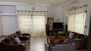 Un salon avec deux canapés, une table basse et un téléviseur.