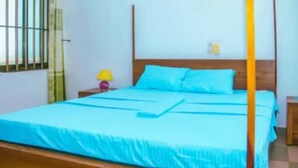 Un lit avec un cadre en bois et une couvre-lit bleue.