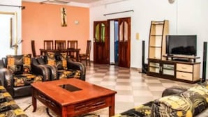 Un salon comprenant un ensemble de canapés, une table basse, un meuble pour la télévision et un coin repas avec des chaises et une table.