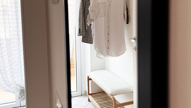 A hallway with a bench, a clothing rack with a white shirt, and a patterned curtain. - Mysa - Your home 5 min from the airport (Isola Sacra)