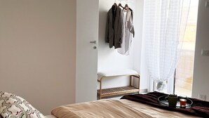 A bedroom with a bed, a wardrobe, a window with sheer curtains, and a tray with a mug and a glass. - Mysa - Your home 5 min from the airport (Isola Sacra)