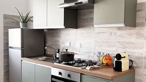 A modern kitchen with grey cabinets, a stainless steel refrigerator, a built-in oven, and a wooden countertop. - Mysa - Your home 5 min from the airport (Isola Sacra)