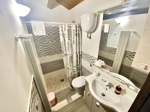 A bathroom with a shower, toilet, sink, and a mirror. - La Dimora Del Golfo (Gaeta)