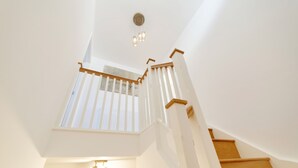 A staircase with wooden steps and white railings, leading to a balcony with a view. - Pass the Keys | Modern & Spacious 1 Bed Terrace with Free Parking (Cambridge)