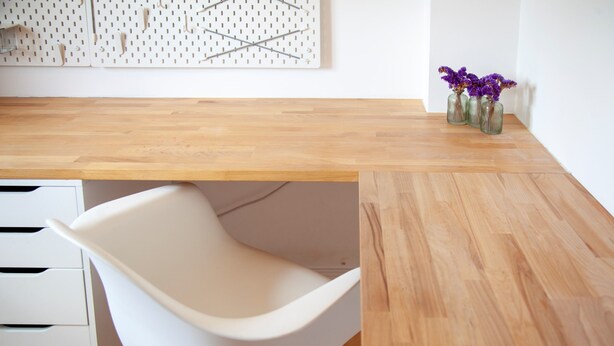 A modern office space with a wooden desk, a white chair, and a pegboard wall. - Pass the Keys | Modern & Spacious 1 Bed Terrace with Free Parking (Cambridge)
