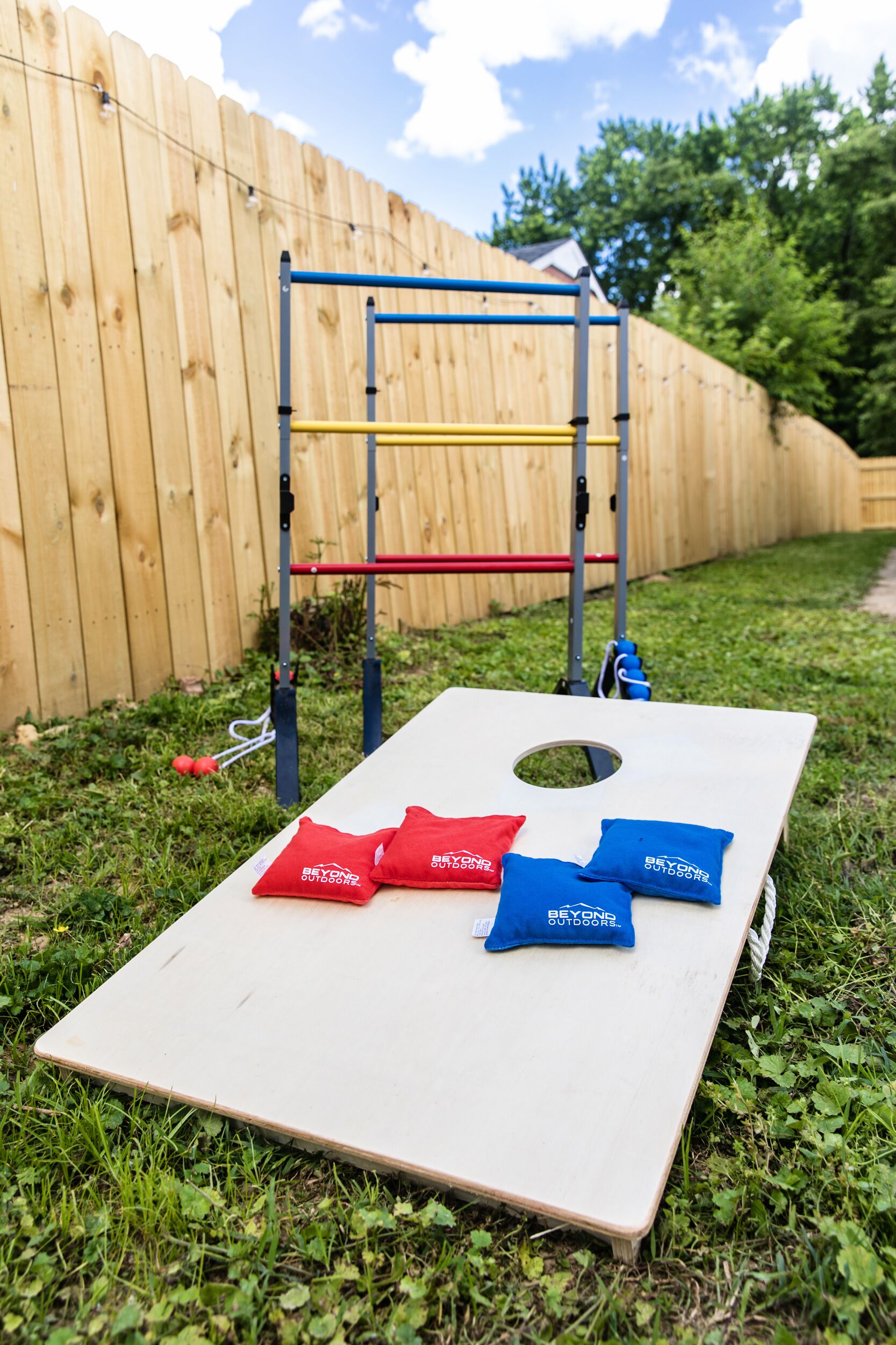A wooden deck with a pull-up bar and a mat with two red and two blue bags.