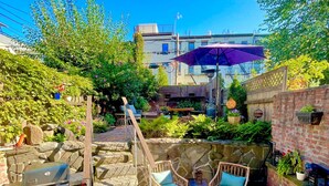 An outdoor patio area with stone steps, wicker furniture, and a barbecue grill. - Modern 2 Bed 2 Bath & Sofa bed w/Dedicated workspace & Large Garden (Brooklyn)