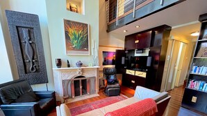 A modern living room with a fireplace, a sofa, a chair, and a bookshelf. - Modern 2 Bed 2 Bath & Sofa bed w/Dedicated workspace & Large Garden (Brooklyn)