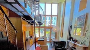 A modern interior with a staircase, a kitchen area, a dining space, and a fireplace. - Modern 2 Bed 2 Bath & Sofa bed w/Dedicated workspace & Large Garden (Brooklyn)