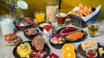 Un assortiment de plats et de boissons pour le petit-déjeuner, disposés sur une table.