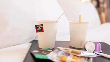 Two disposable cups with straws on a tray, a packet of cigarettes, and a lighter.