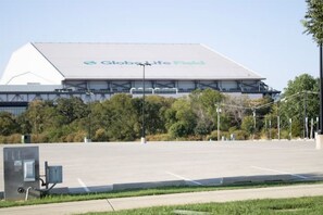 Un estadio grande con el nombre 'Global Life Field' en el techo, rodeado de árboles y un estacionamiento.
