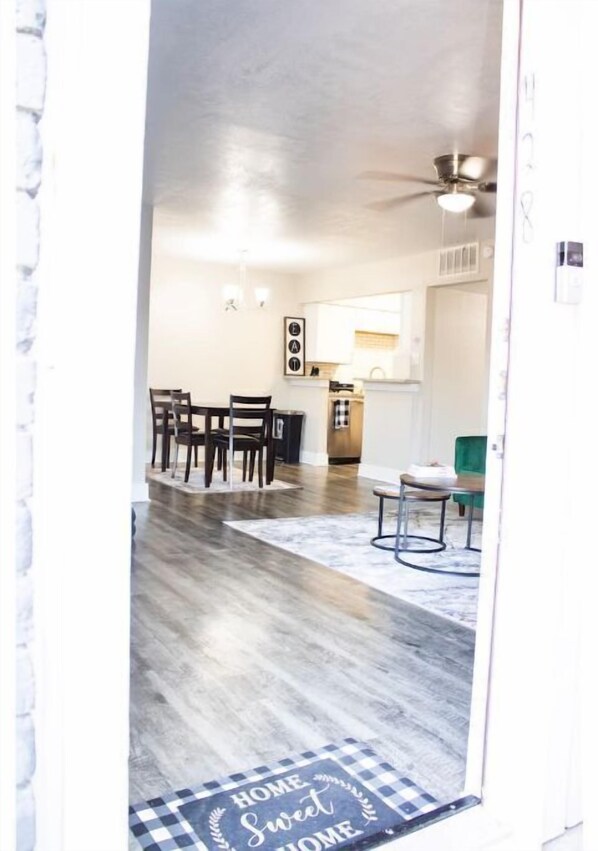 Enjoy meals in the dining area with a wooden table and four chairs, surrounded by a cozy rug.
